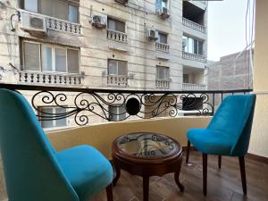 a balcony with two chairs and a table and a building at Golden Gem Hotel in Cairo