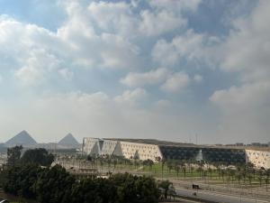 een uitzicht op een gebouw met piramides op de achtergrond bij Golden Gem Hotel in Caïro