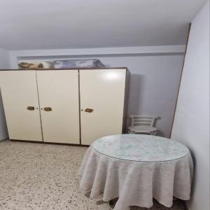 Zimmer mit einem Tisch und einem weißen Schrank in der Unterkunft luxe in Motril