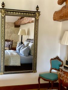 a mirror in a bedroom with a bed and a chair at Chateau Masburel in Fougueyrolles +13 photos