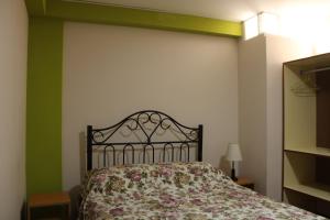 1 Schlafzimmer mit einem Bett mit Blumenbettdecke in der Unterkunft 2 de Mayo Apartamento 2do piso in Tacna