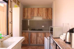 cocina con armarios de madera y microondas en 2 de Mayo Apartamento 2do piso, en Tacna