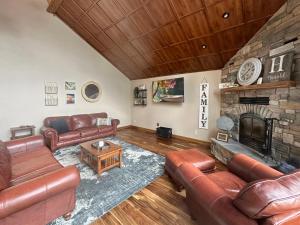 a living room with leather furniture and a stone fireplace at Lakeside 2br Retreat Relax And Reconnect 