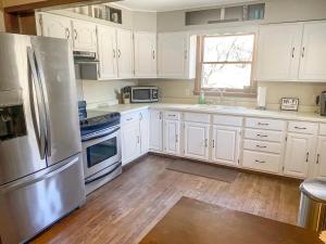 a kitchen with white cabinets and a stainless steel refrigerator at Huge Secluded 5 Bedroom 2 12 Bathroom Home! in Ontario