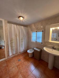 a bathroom with a sink and a toilet and a window at Casa Los Belenes in Cazorla