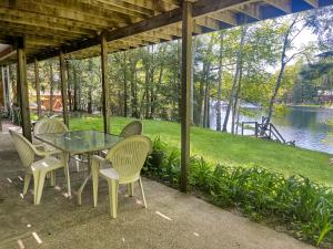a table and chairs with a view of a lake at 2br Lakeside Haven Relax On Long Lake in Gleason
