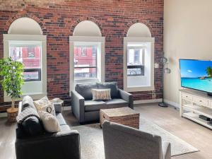 a living room with furniture and a brick wall at Cozy 3br Downtown Bakery & Shops! in La Crosse