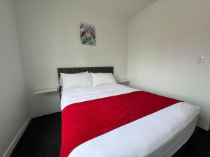 a bedroom with a white bed with a red blanket at Central Boutique Hotel in Oranjestad