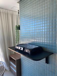 a blue tiled kitchen with a grill on a shelf at Anfitrião Guiah! - Desperte os sentidos a beira-mar e ao lado do Centro de Convenções in Salvador