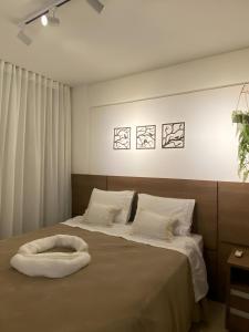 a bedroom with two beds with white pillows at The Place Beach Aparts: desperte os melhores sentidos a beira-mar e ao lado do centro de convenções. in Salvador