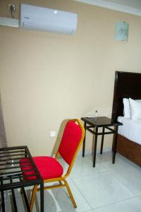Zimmer mit einem Stuhl, einem Bett und einem Tisch in der Unterkunft Kamanga Safari Lodge in Maun