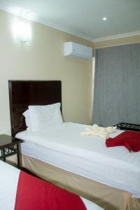 1 Schlafzimmer mit 2 Betten mit weißer Bettwäsche und einem Fenster in der Unterkunft Kamanga Safari Lodge in Maun