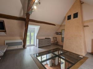 a living room with a glass table in a room at Gîte spacieux en pleine nature avec grand jardin, activités extérieures, proche sites historiques et commerces - FR-1-591-185 in Sarzay