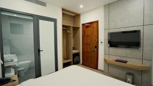 um quarto com uma cama, uma televisão e uma casa de banho em Thành Thuý Hotel em Buon Ma Thuot
