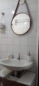 uma casa de banho com um lavatório branco e um espelho. em A poucos passos da Av. Paulista! em São Paulo