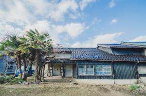 a house with two palm trees in front of it at A310to 河崎浪漫館 in Sado