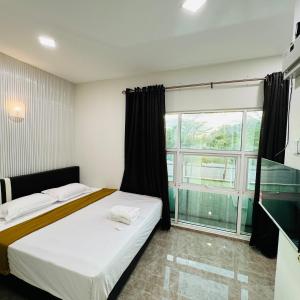 1 dormitorio con cama y ventana grande en Rayyaz Inn en Kuala Terengganu