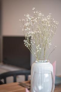 un jarrón blanco con flores blancas en una mesa en Apartment Strauss #FÜNF - 3 Zimmer BS-City, en Brunswick