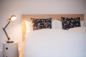 1 dormitorio con 1 cama con lámpara y almohadas en Apartment Strauss #FÜNF - 3 Zimmer BS-City, en Brunswick