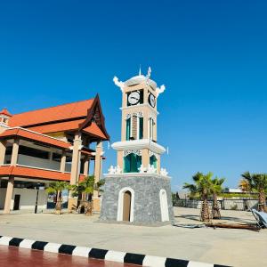 una torre de reloj frente a un edificio en Rayyaz Inn en Kuala Terengganu