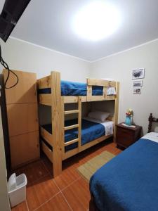 a bedroom with two bunk beds and a blue bed at Ohana Hostel in Ica