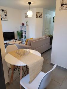 een woonkamer met een tafel en een bank bij Cocooning House 212 Suite COSY SUNSHINE appartement Aeroport Paris Roissy CDG et Parc Asterix in Survilliers