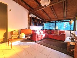 uma sala de estar com um sofá vermelho e uma mesa em El Refugio de San Matías em Guanajuato