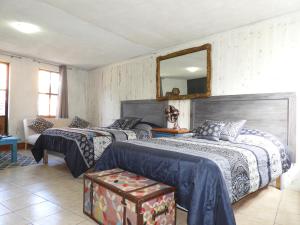 1 dormitorio con 2 camas y espejo en El Refugio de San Matías en Guanajuato