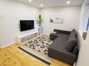 a living room with a couch and a flat screen tv at Chalet in the Laurentian Mountains in Sainte-Agathe-des-Monts