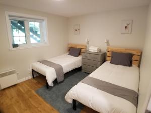 a bedroom with two beds and a window at Chalet in the Laurentian Mountains in Sainte-Agathe-des-Monts