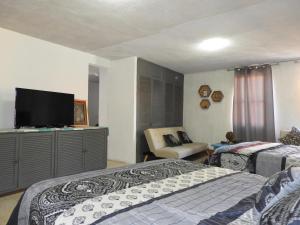 a bedroom with two beds and a flat screen tv at El Refugio de San Matías in Guanajuato