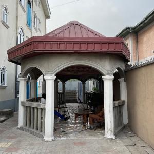 a gazebo with a red roof on a building at Serenity Place in Limbe