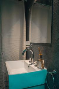 een badkamer met een witte wastafel en een spiegel bij MI LUGAR * CHIVILCOY in Chivilcoy