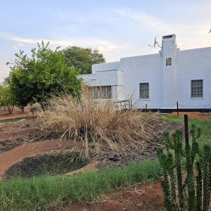 un edificio blanco con un molino de viento a su lado en Mukamba Holiday House en Livingstone