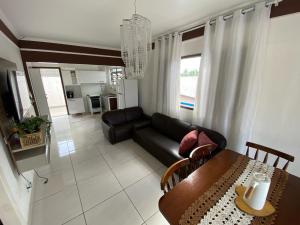 sala de estar con sofá negro y mesa en Beach House, en Mongaguá