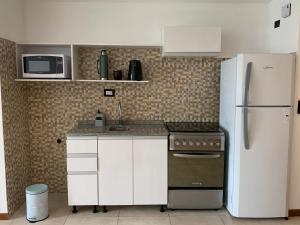 a kitchen with white cabinets and a refrigerator at Monoambiente nuevo y luminoso en Flores in Buenos Aires
