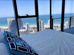 a bed in a room with a view of the city at Magnificent Full Ocean View at Casino Free Parking in Gold Coast