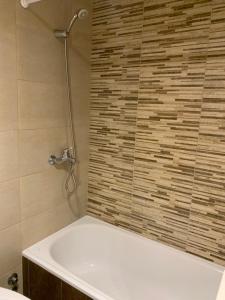 La salle de bains est pourvue d'une baignoire et d'une douche. dans l'établissement Monoambiente nuevo y luminoso en Flores, à Buenos Aires