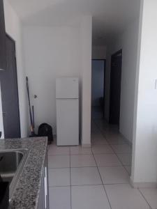 a kitchen with a white refrigerator in a room at PH OLAS TOWERS FRONT. PLAYA LA BARQUETA in Chiriquí