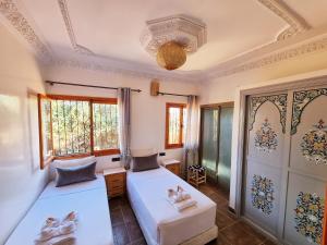 1 dormitorio con 2 camas y ventana en Villa des étoiles, en Ourika