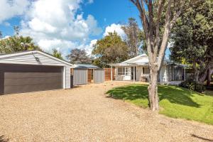 a house with a driveway and a garage at Miami one one in Oneroa