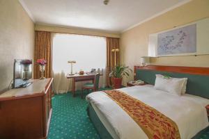 Pokój hotelowy z łóżkiem i biurkiem w obiekcie CITIC Hotel Beijing Airport w mieście Shunyi
