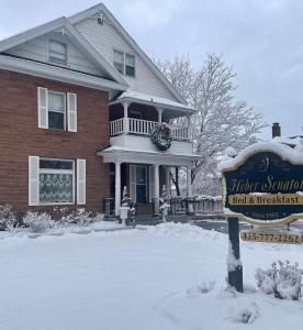 a house with a sign in the snow at Heber Senator Bed and Breakfast in Heber City