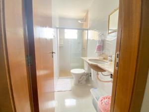 a bathroom with a shower and a toilet and a sink at Linda casa beira da praia in Lauro de Freitas