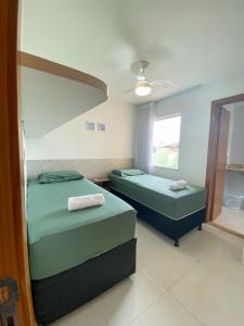 a bedroom with two beds and a ceiling at Linda casa beira da praia in Lauro de Freitas