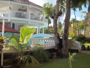 a large white house with a balcony and palm trees at Hotel V. Maria in Eslabón