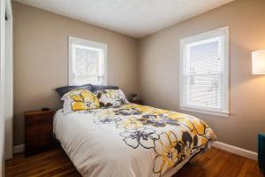 a bedroom with a bed and two windows at Colonial Village Retreat 2BR in New Albany