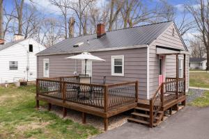 ein kleines Haus mit einer Terrasse und einem Sonnenschirm in der Unterkunft Colonial Village Retreat 2BR in New Albany