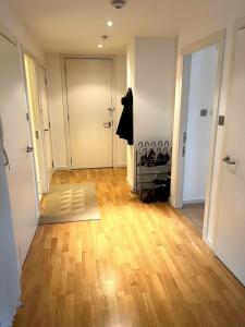 um corredor vazio com uma porta e um piso de madeira em Spacious Queen Bed City Centre Penthouse With Balcony - Homeshare - Live In Host em Glasgow