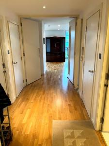 an empty hallway with wood floors and white doors at Spacious Queen Bed City Centre Penthouse With Balcony - Homeshare - Live In Host in Glasgow